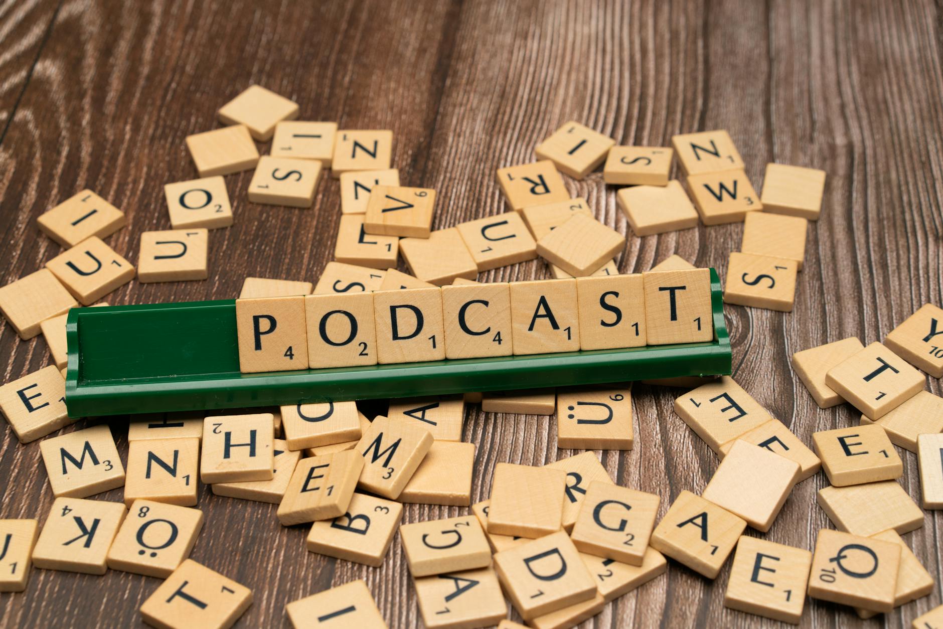 the word podcast on a wooden table with scrabble tiles